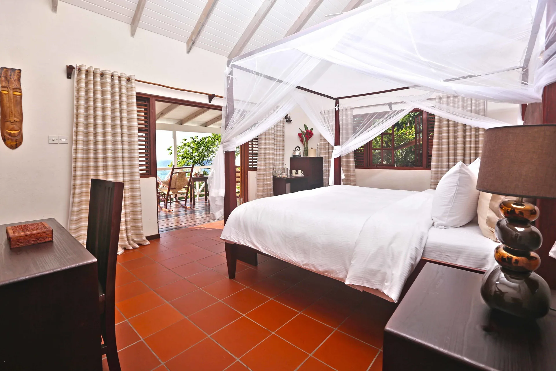 Ocean View Cottage with Pool bedroom at Ti Kaye Resort & Spa with four-poster bed and balcony doors.