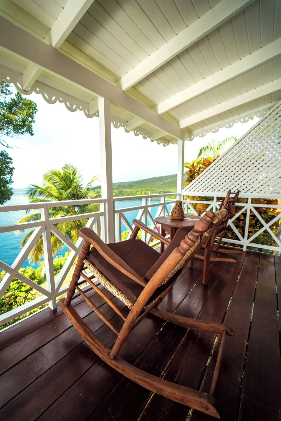 Ocean View Cottage veranda with wooden rocking chairs and coastline view at Ti Kaye Resort & Spa.