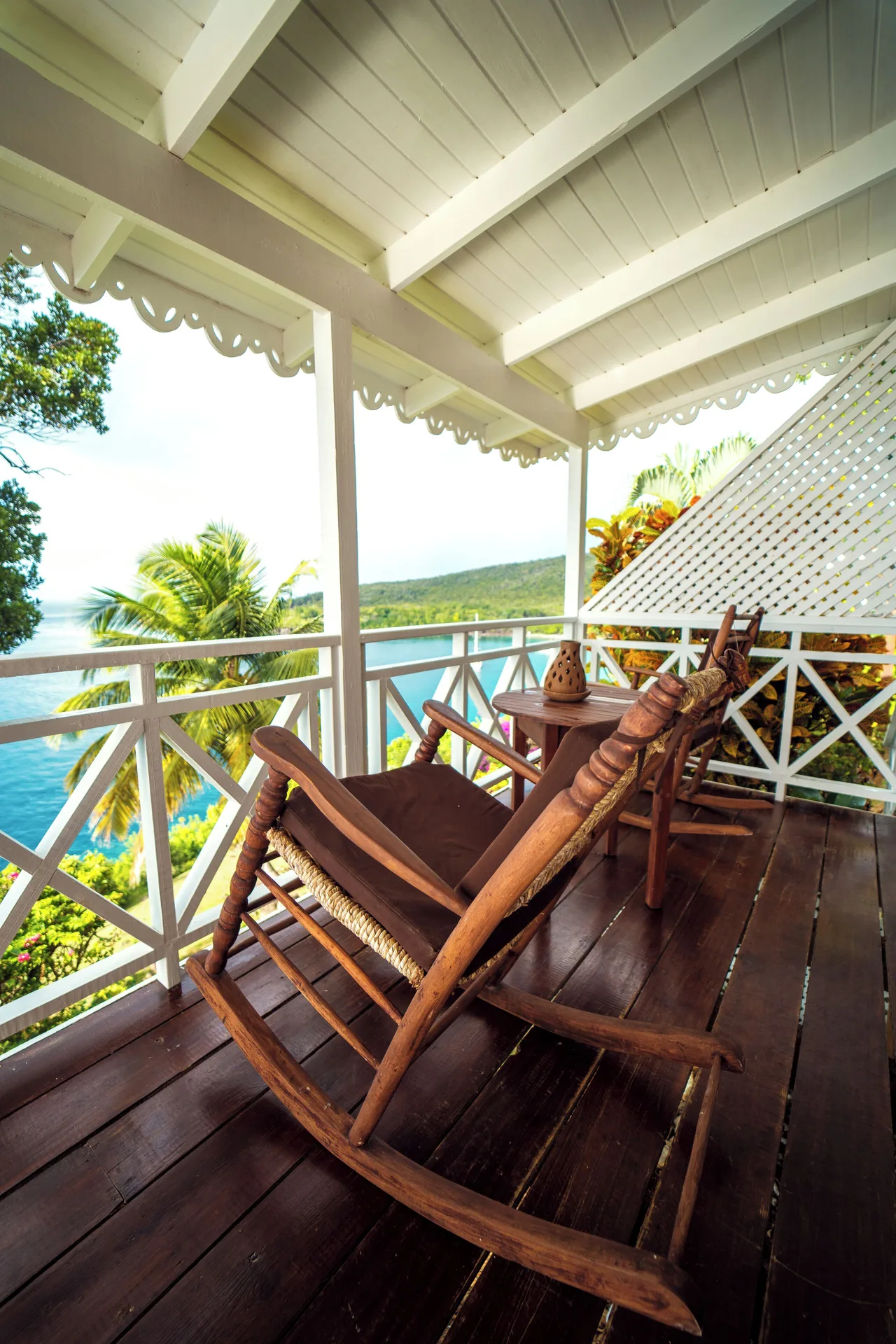 Ocean View Cottage veranda with wooden rocking chairs and coastline view at Ti Kaye Resort & Spa.