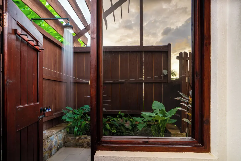 Ocean View Cottage with Pool outdoor shower at Ti Kaye Resort & Spa with wooden walls and tropical plants.