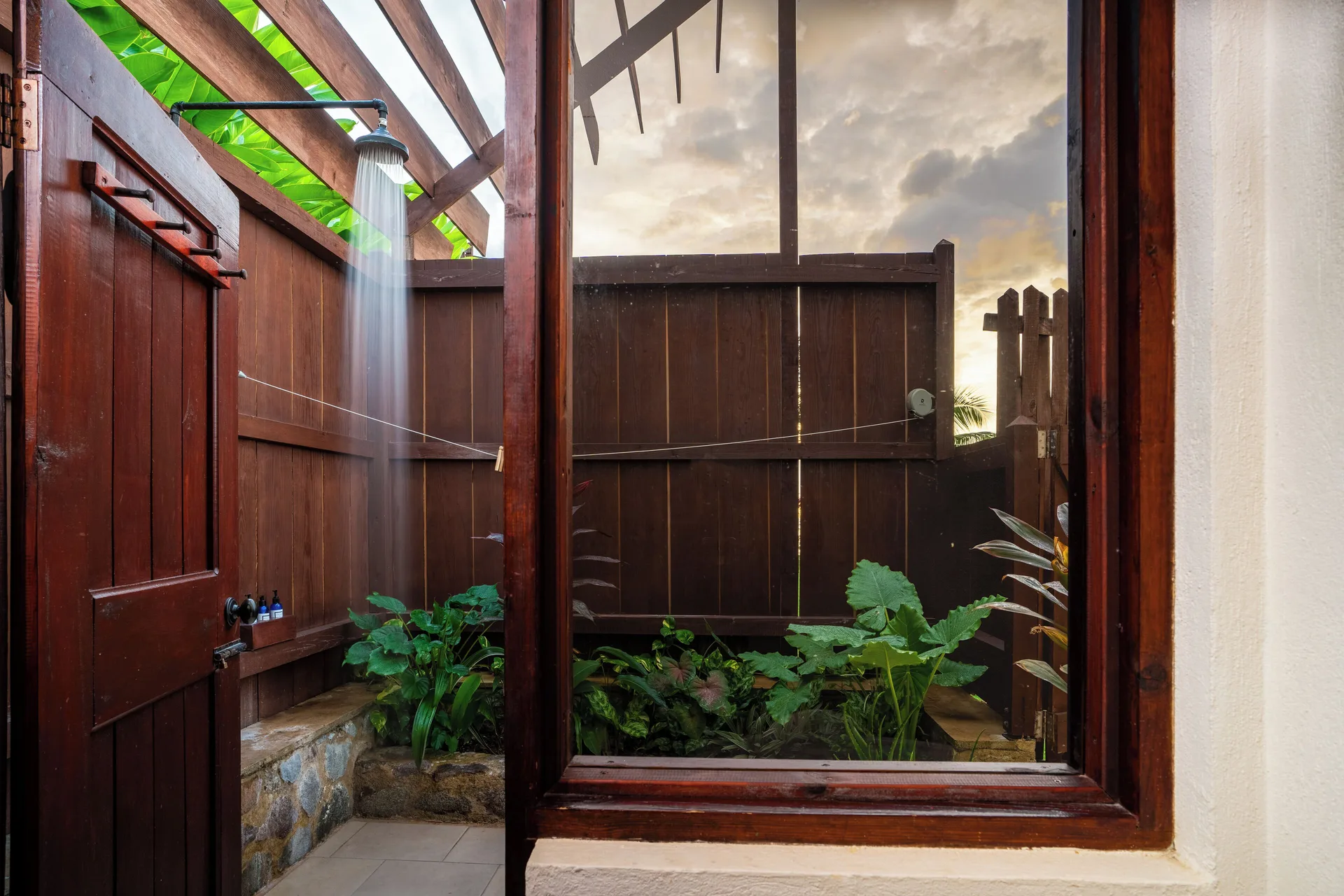 Ocean View Cottage with Pool outdoor shower at Ti Kaye Resort & Spa with wooden walls and tropical plants.