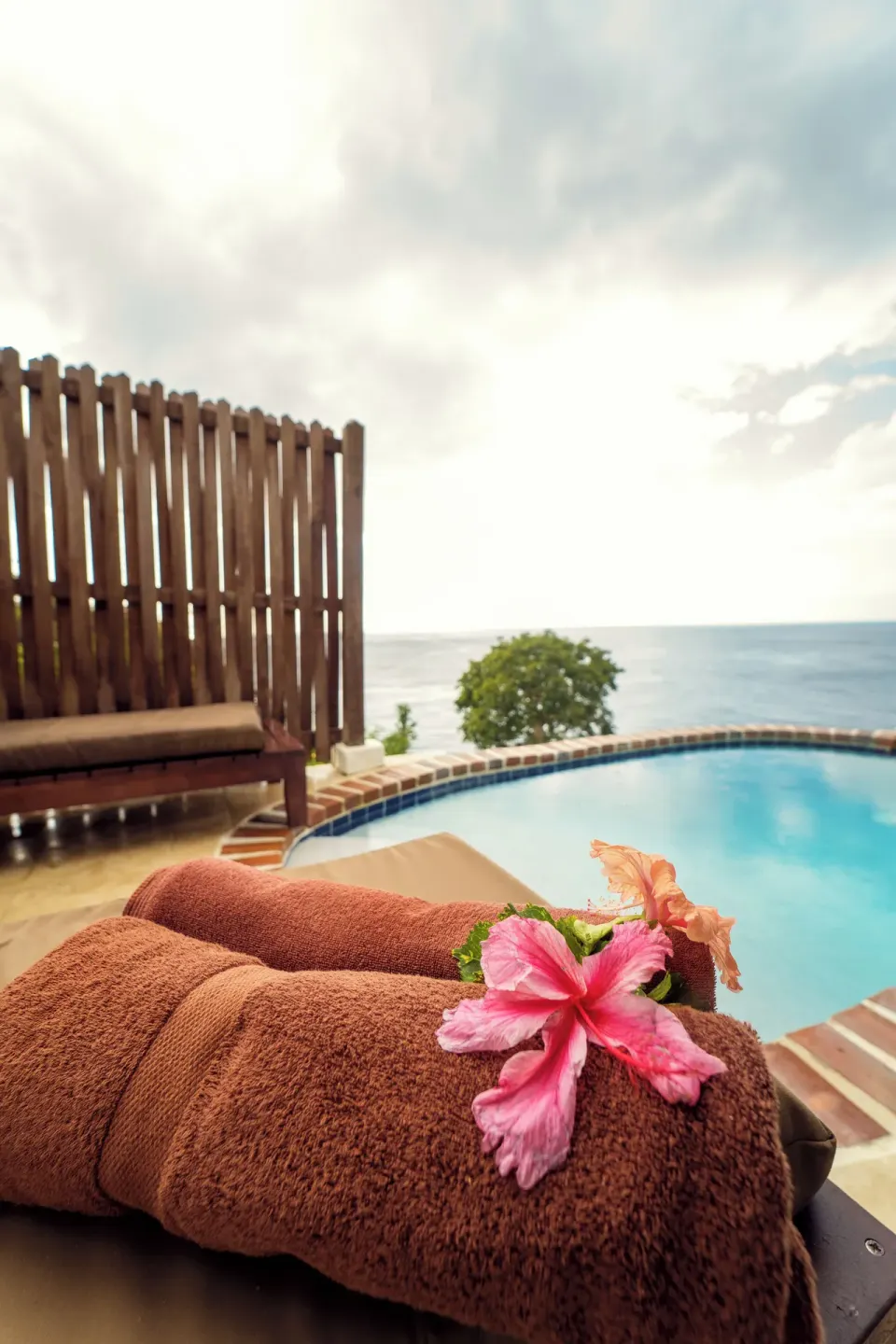 Poolside towels and hibiscus by the Ocean View Cottage with Pool at Ti Kaye Resort & Spa.
