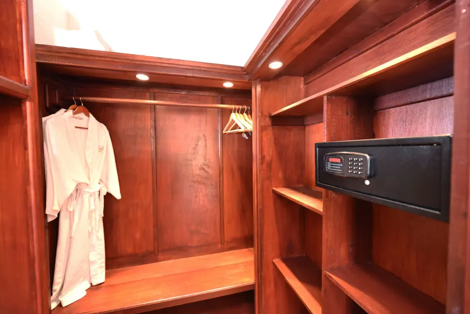 Wooden closet with robe, hangers, shelves, and safe in an Ocean View Room at Ti Kaye Resort & Spa.