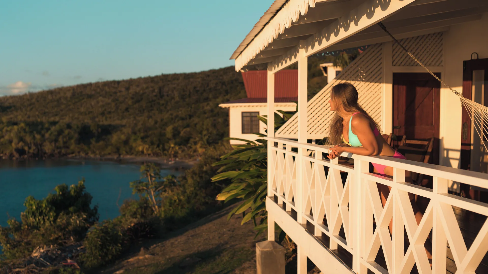 Romantic Cabin balcony with a guest overlooking the bay at Ti Kaye Resort & Spa.
