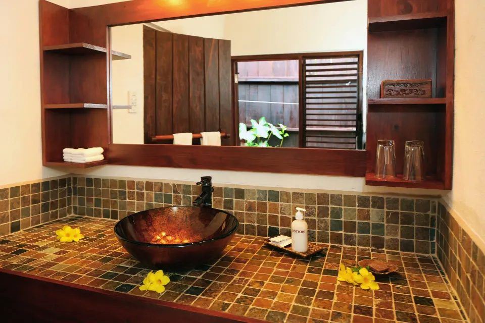 Ocean View room bathroom vanity with vessel sink and mirror at Ti Kaye Resort & Spa.