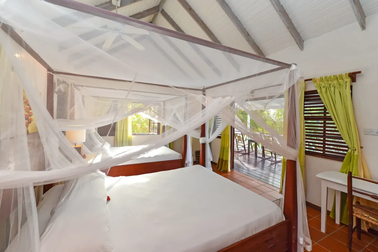 Ocean View room with mosquito-netted bed and balcony doors at Ti Kaye Resort & Spa.