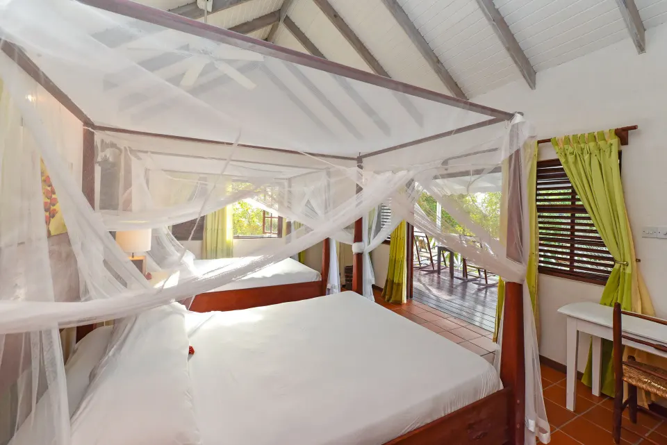 Ocean View room with mosquito-netted bed and balcony doors at Ti Kaye Resort & Spa.