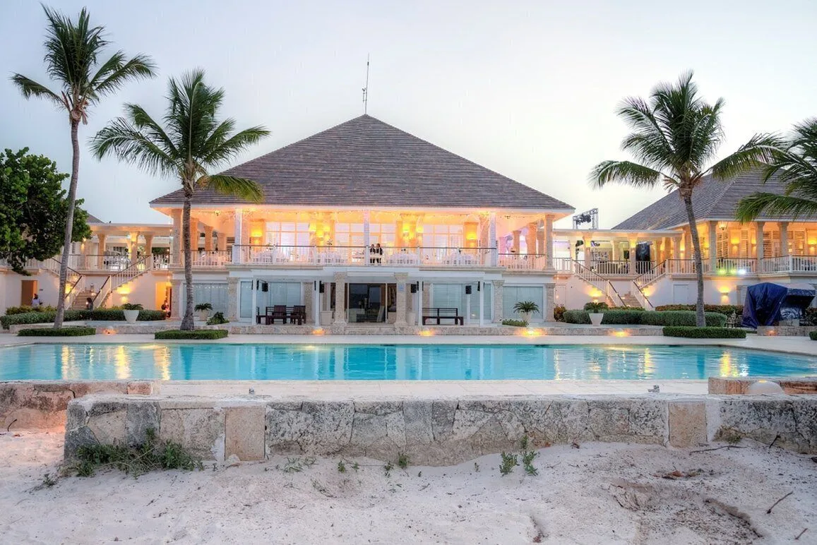 Beachfront pool and illuminated resort buildings at dusk at Tortuga Bay Hotel.