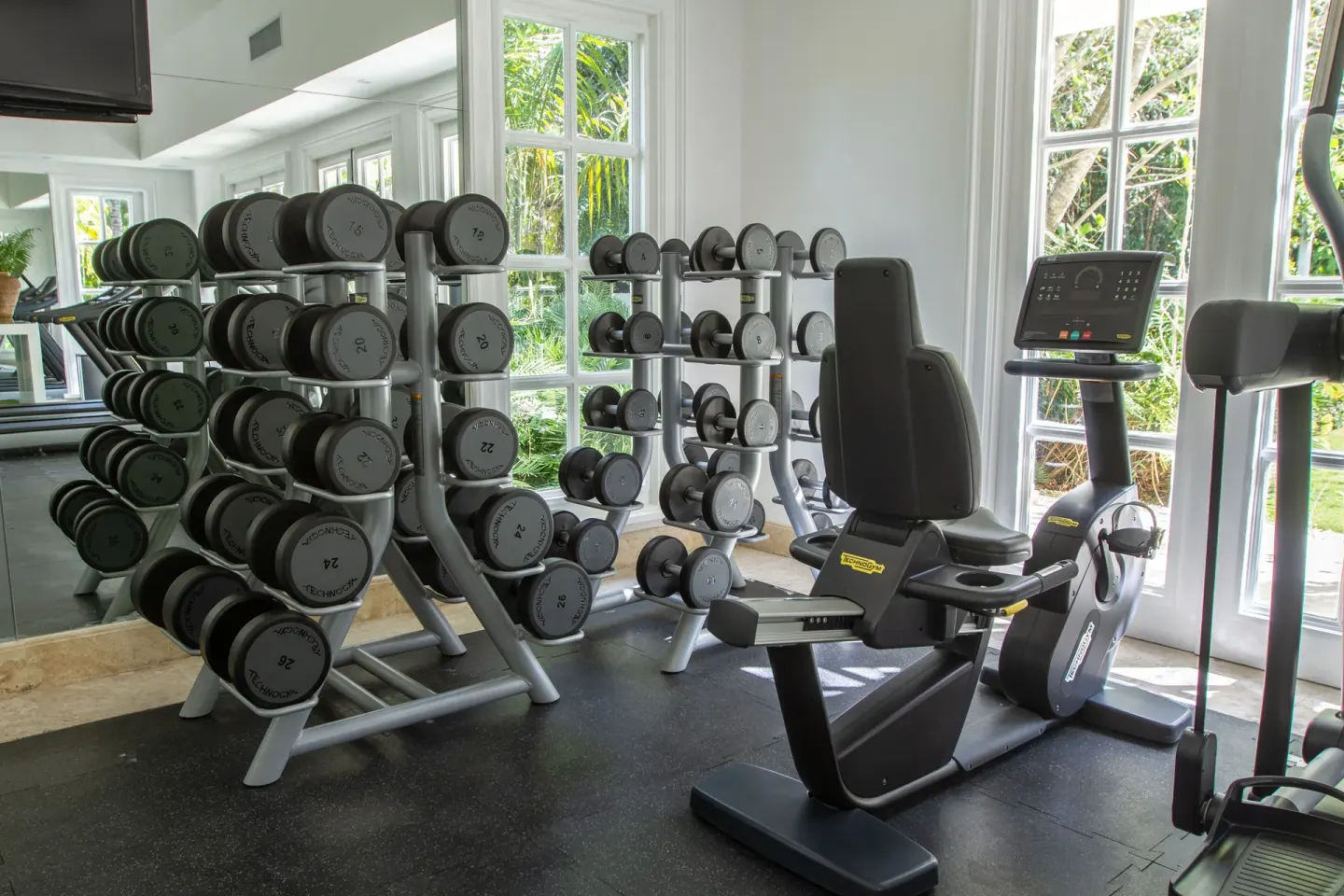 Dumbbell racks and a seated exercise bike in the gym at Tortuga Bay Hotel.