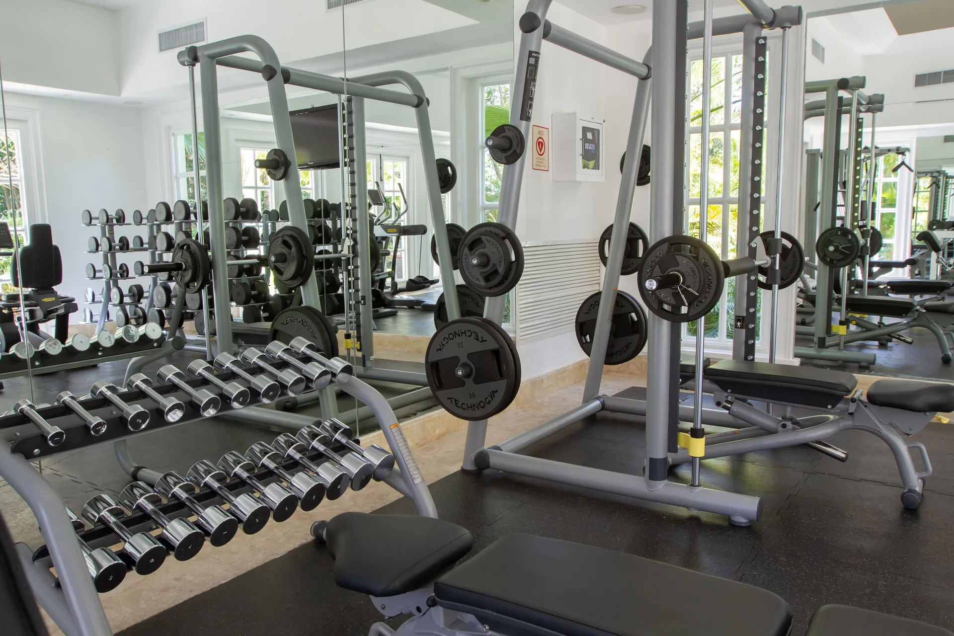 Weight benches, dumbbells, and strength machines in the gym at Tortuga Bay Hotel.