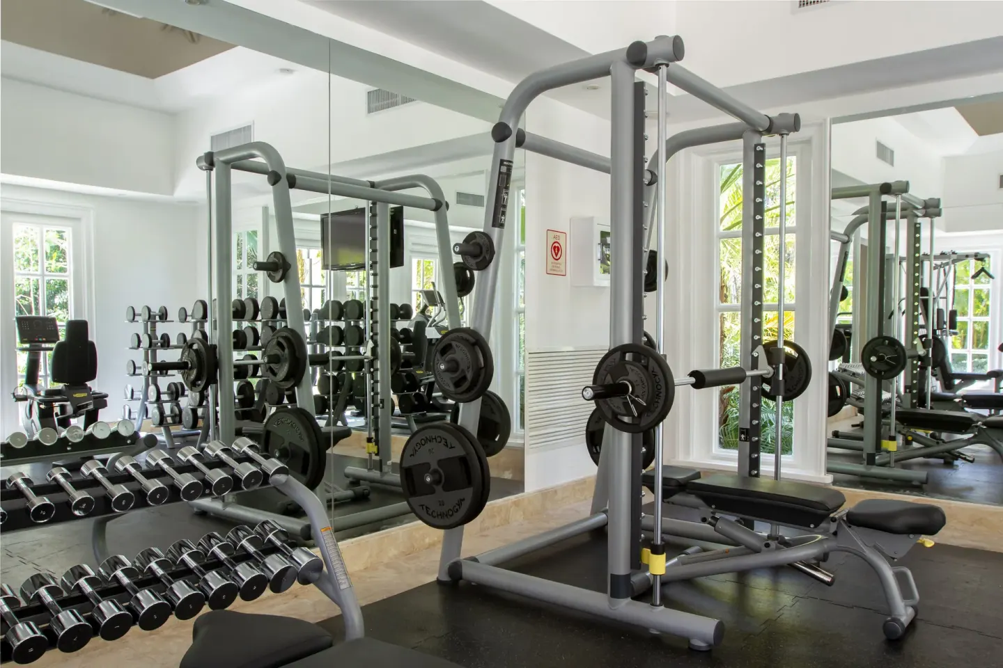Mirrored gym with dumbbells and weight equipment at Tortuga Bay Hotel.