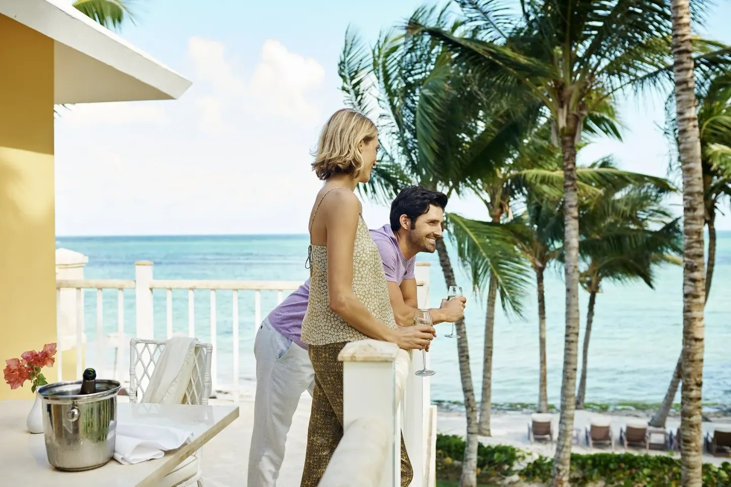 Couple with drinks on an ocean-view balcony at Tortuga Bay Hotel.