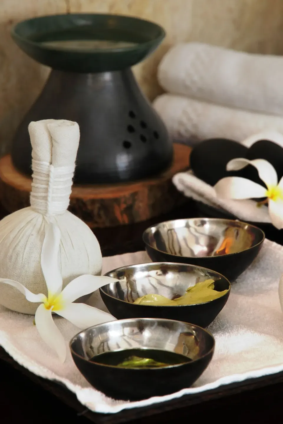 Spa bowls, towels, flowers, and treatment items are arranged at Tortuga Bay Hotel.