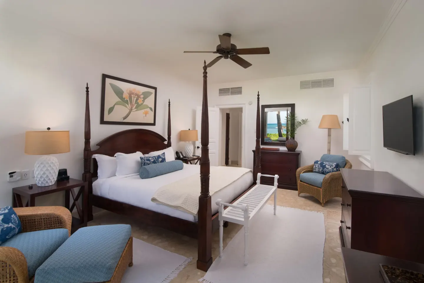 Beach Front Junior Suite bedroom with four-poster bed and seating at Tortuga Bay Hotel.