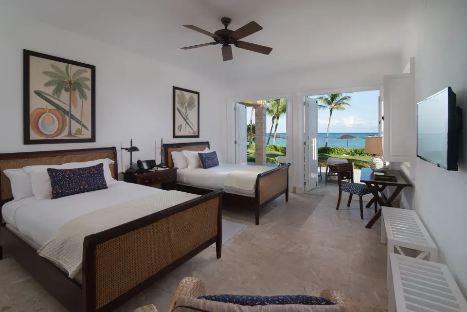 Beach Front Two Bedrooms Suite twin beds with ocean-facing terrace at Tortuga Bay Hotel.