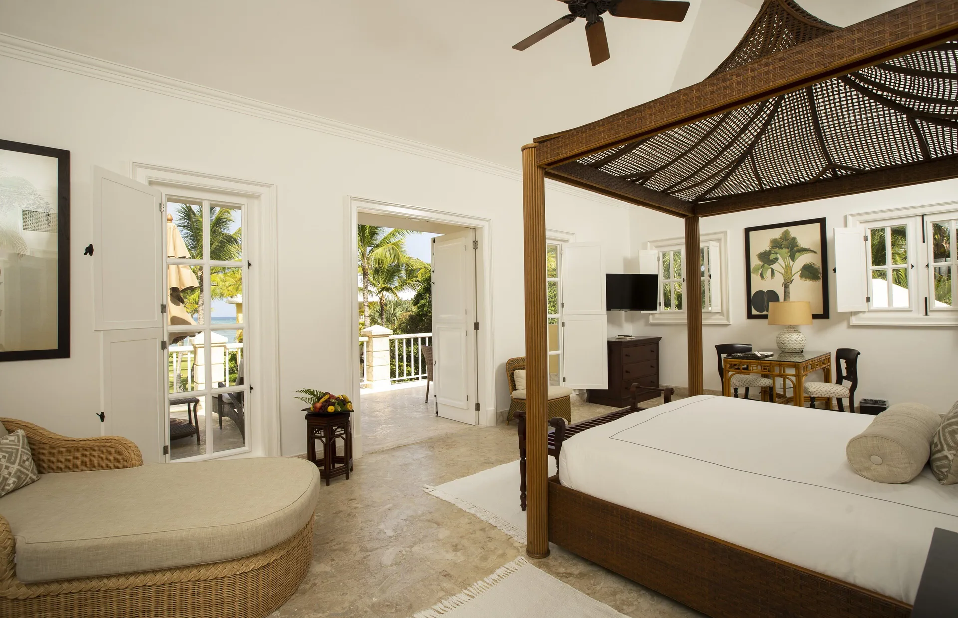 Ocean View Junior Suite bed, chaise, and balcony doors at Tortuga Bay Hotel.