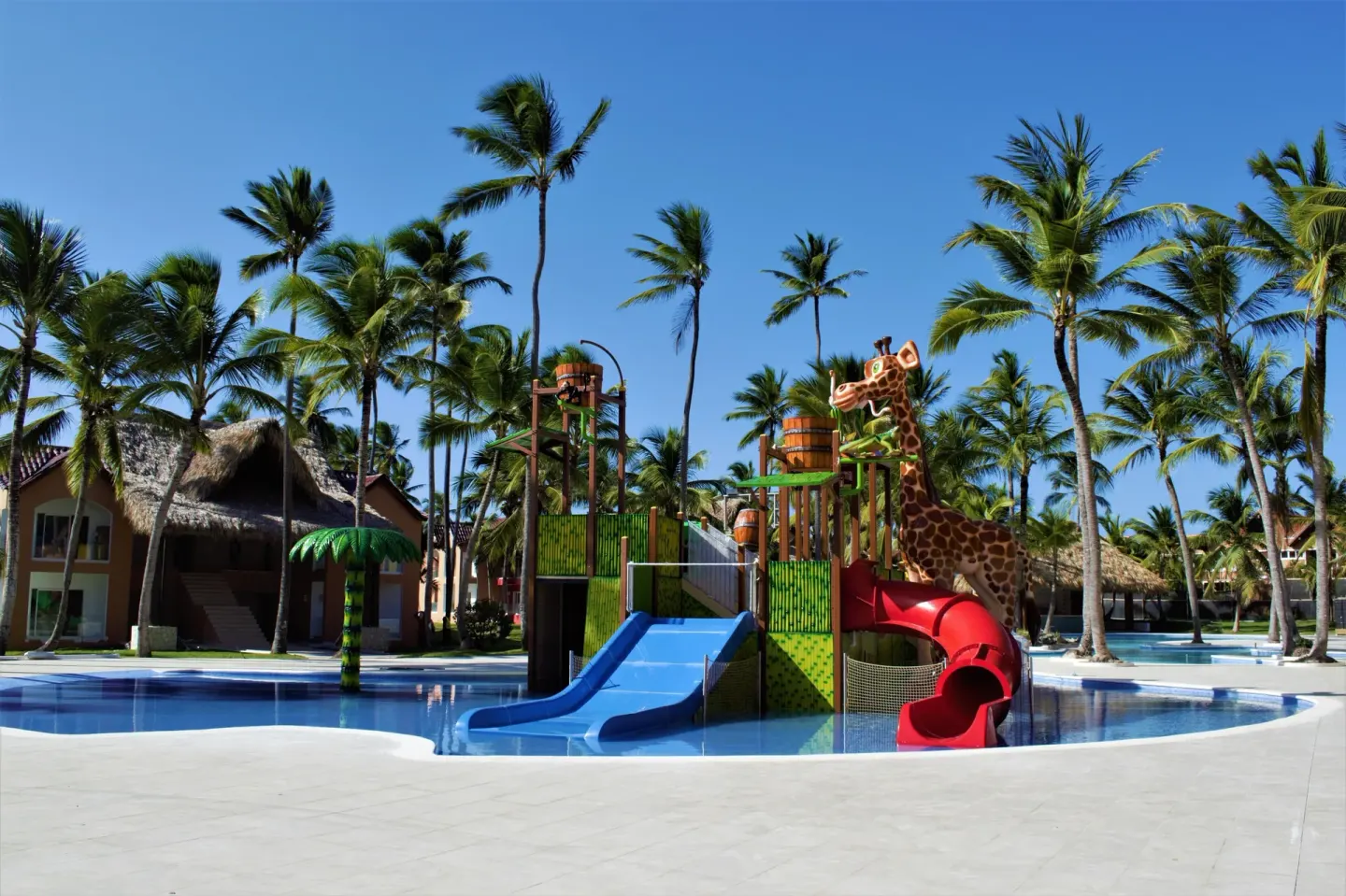 Children's pool play structure with blue and red slides at Tropical Deluxe Princess.