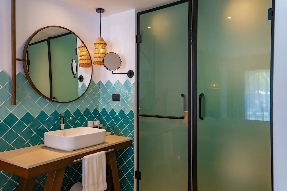 Guest bathroom with turquoise tile and glass shower at Tropical Deluxe Princess.