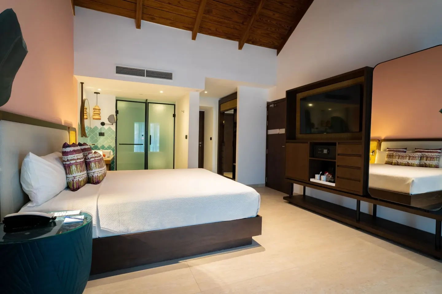 King-bed guest room with mirrored cabinet and open bathroom area at Tropical Deluxe Princess.
