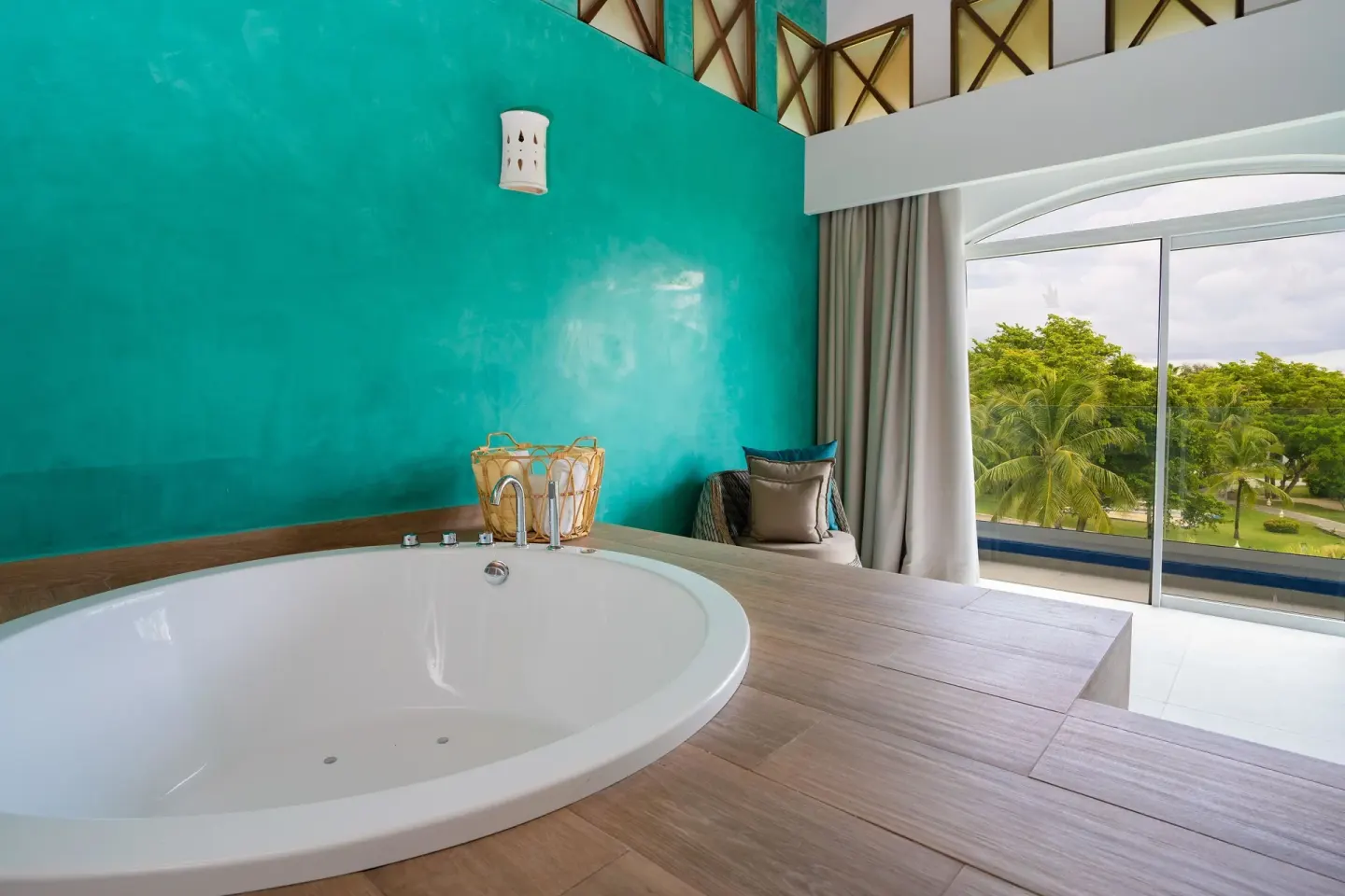 In-room soaking tub beside large windows with garden view at Tropical Deluxe Princess.