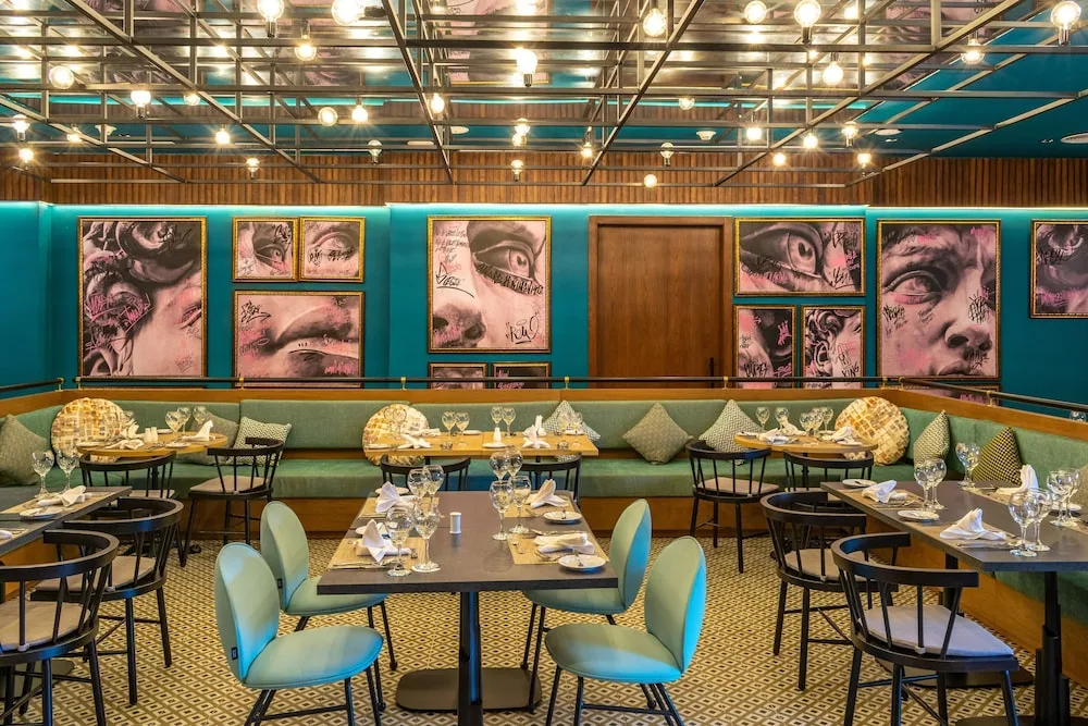Dining room with teal walls and art panels at Tropical Deluxe Princess.