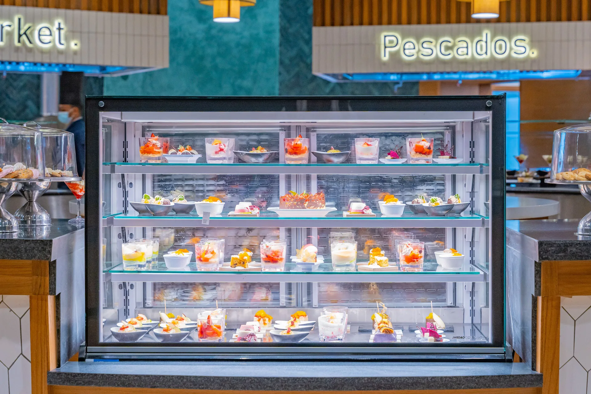 Chilled display case with small desserts and seafood station signage at Tropical Deluxe Princess.