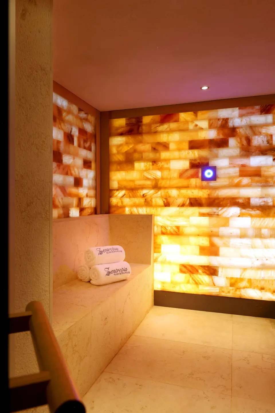 Spa relaxation alcove with glowing amber wall and folded towels at TRS Coral Hotel.