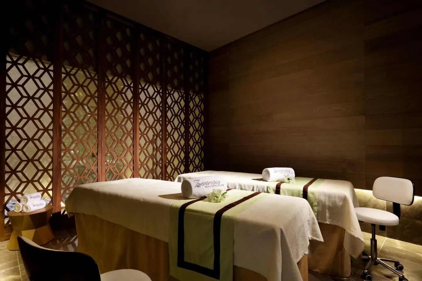 Couples treatment room with two massage tables and wood screens at TRS Coral Hotel.