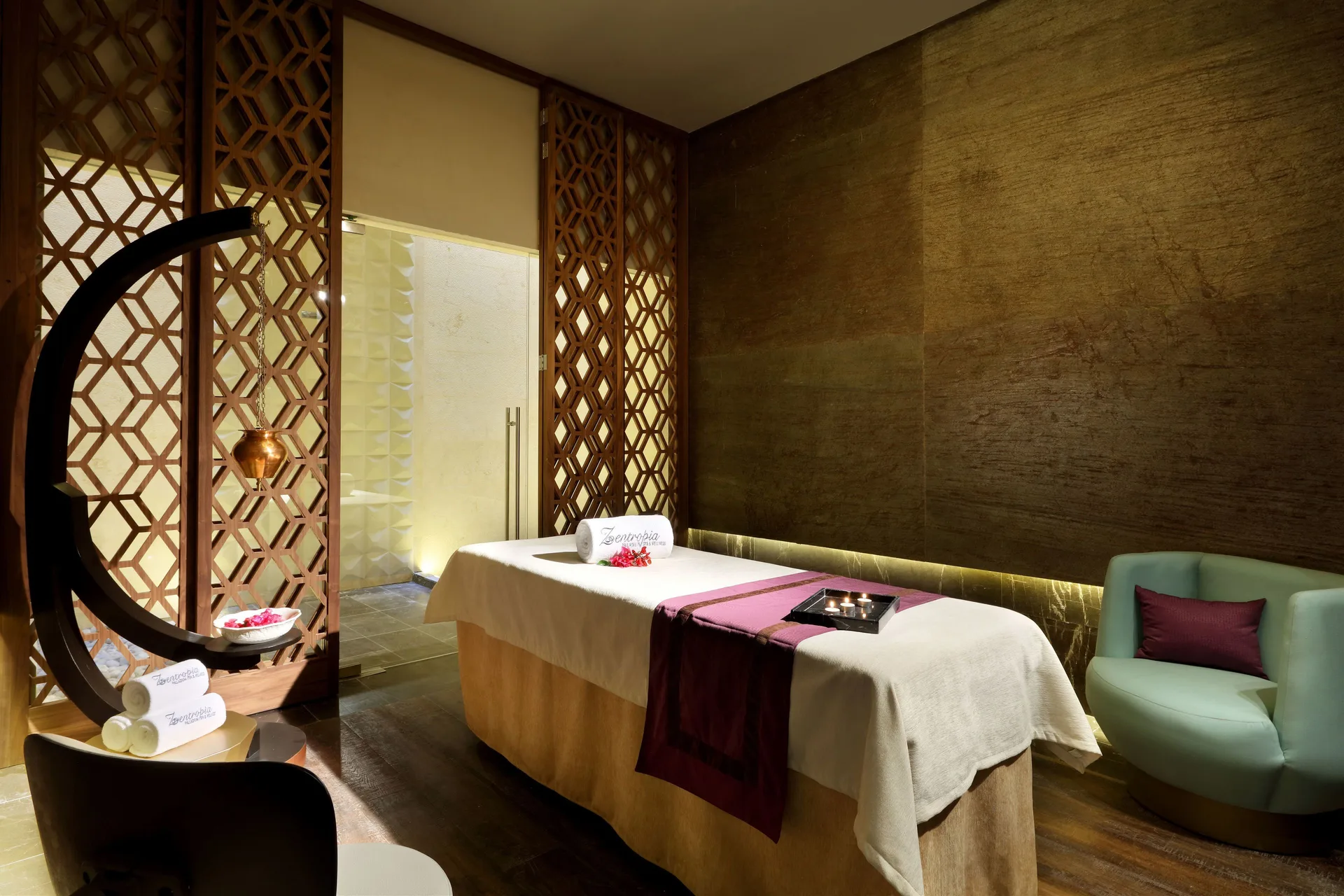 Massage treatment room with table and wood screens at TRS Coral Hotel.
