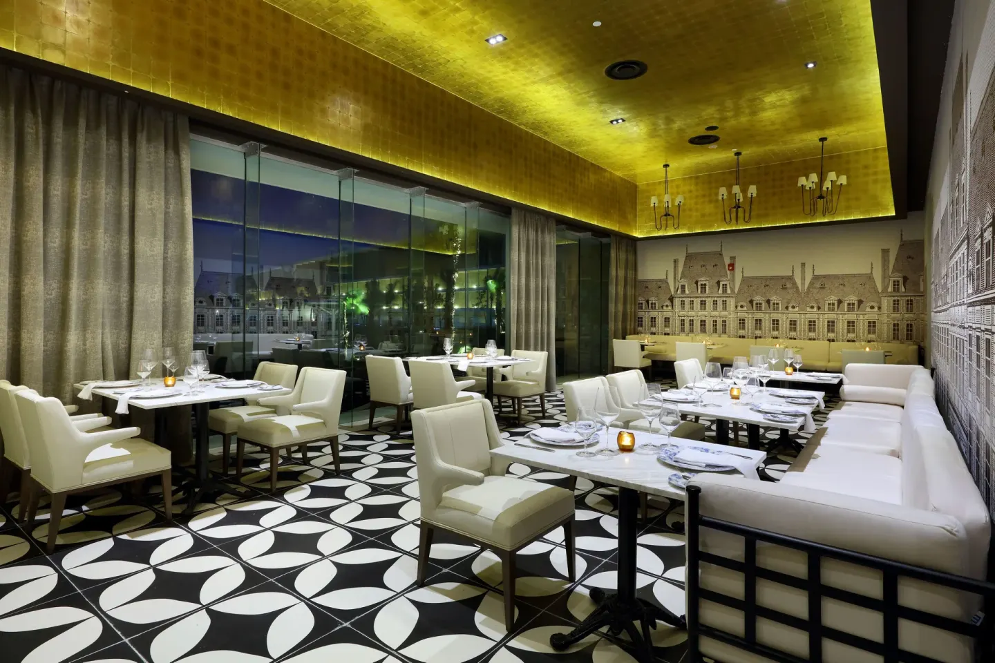 French-style dining room with gold ceiling and white chairs at TRS Coral Hotel.