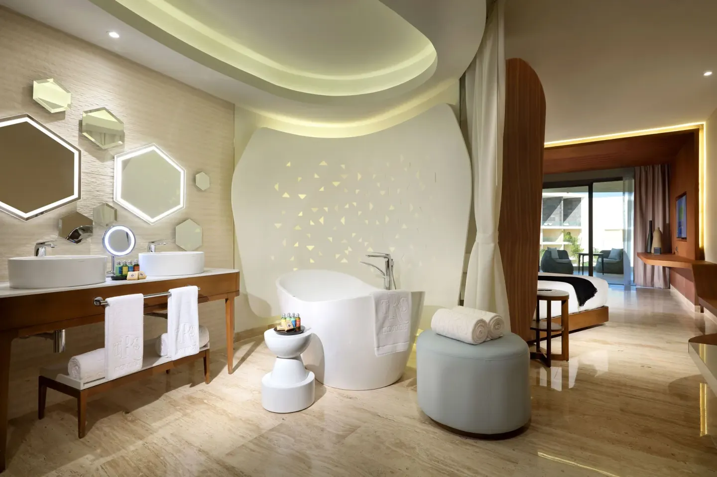 Junior Suite bathroom with freestanding tub, double vanity, and bedroom beyond at TRS Coral Hotel.
