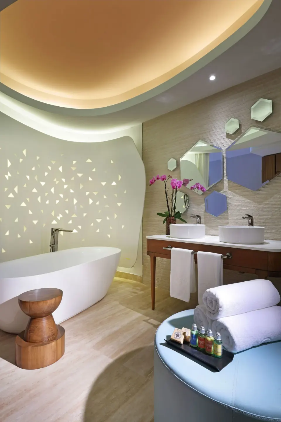 Junior Suite bathroom with oval tub, double sinks, towels, and mirrors at TRS Coral Hotel.
