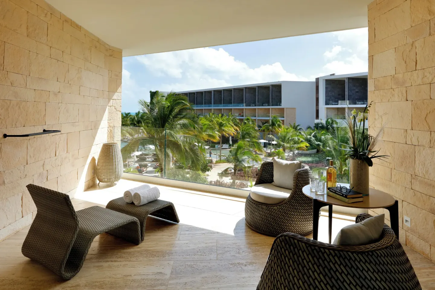 Junior Suite terrace with lounge chairs and garden-facing glass railing at TRS Coral Hotel.