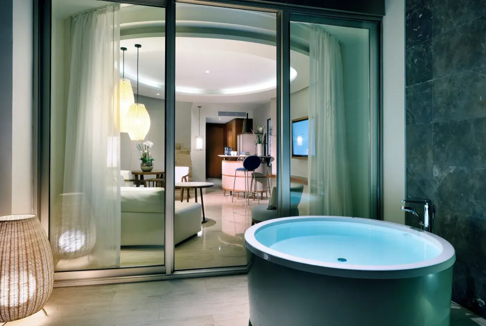 Terrace Jacuzzi outside a Loft Suite at TRS Coral Hotel, with the living room visible through glass doors.