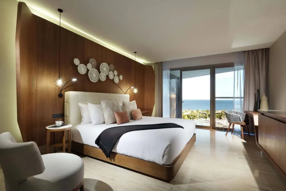 Loft Suite Ocean View bedroom with king bed and balcony view at TRS Coral Hotel.