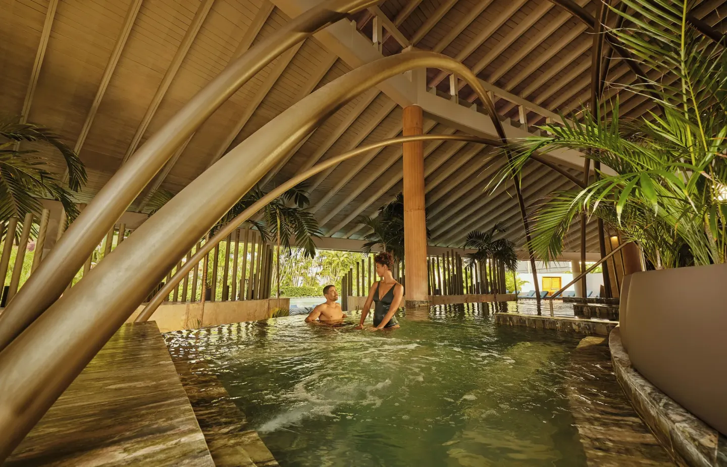 Covered spa pool with two guests under a peaked roof at TRS Turquesa Hotel.