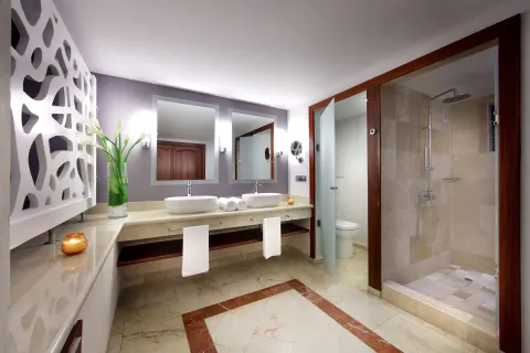 Double-vanity bathroom with glass shower at TRS Turquesa Hotel.