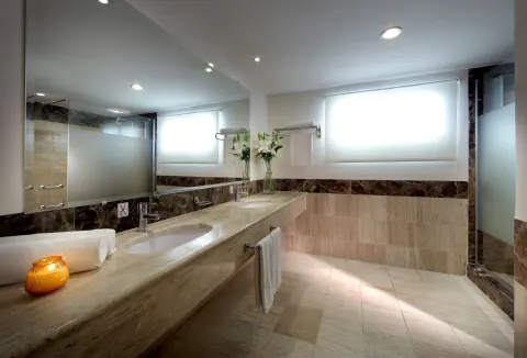 Marble bathroom vanity with frosted-glass shower at TRS Turquesa Hotel.