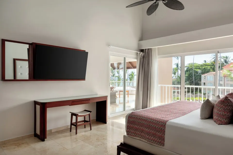 Jacuzzi Terrace Suite Beachside king bed by balcony doors at TRS Turquesa Hotel.
