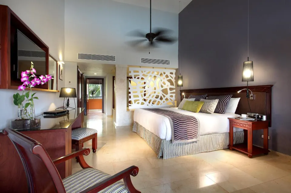 Junior Suite Garden Pool View bedroom with king bed and desk at TRS Turquesa Hotel.