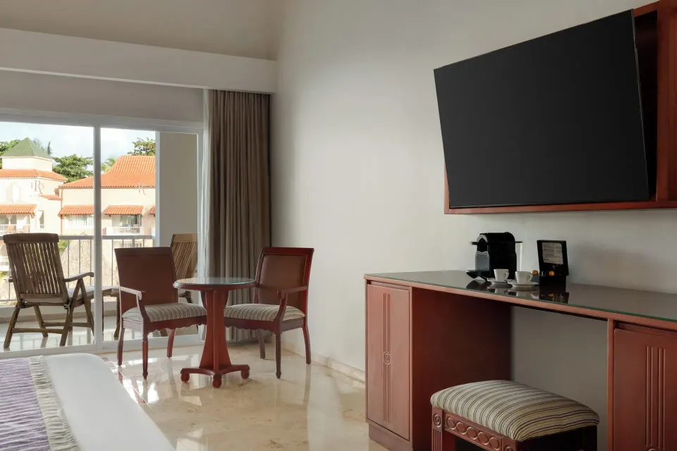 Junior Suite Poolside room with TV, desk, seating, and balcony at TRS Turquesa Hotel.