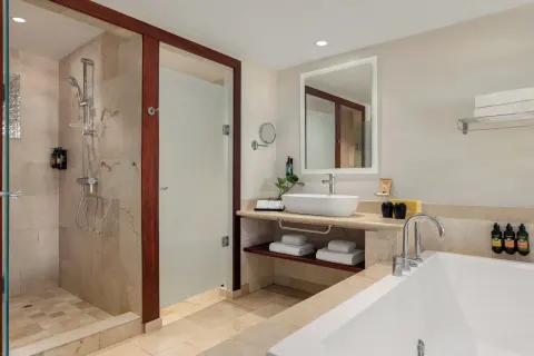 Junior Suite Poolside bathroom with tub, vanity, shower, and towels at TRS Turquesa Hotel.