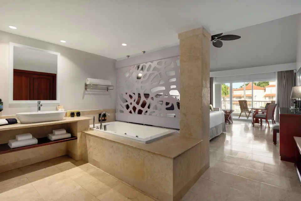 Junior Suite Poolside open bathroom with tub beside the bedroom at TRS Turquesa Hotel.