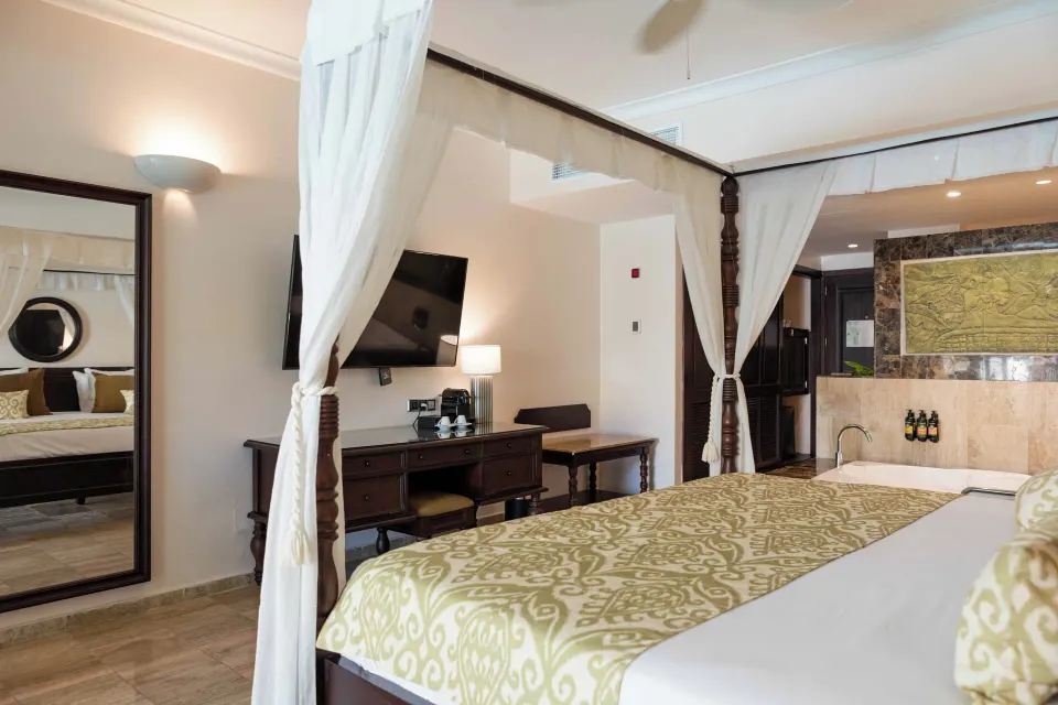 Junior Suite Swim Up canopy bed with desk, TV and tub at TRS Turquesa Hotel.