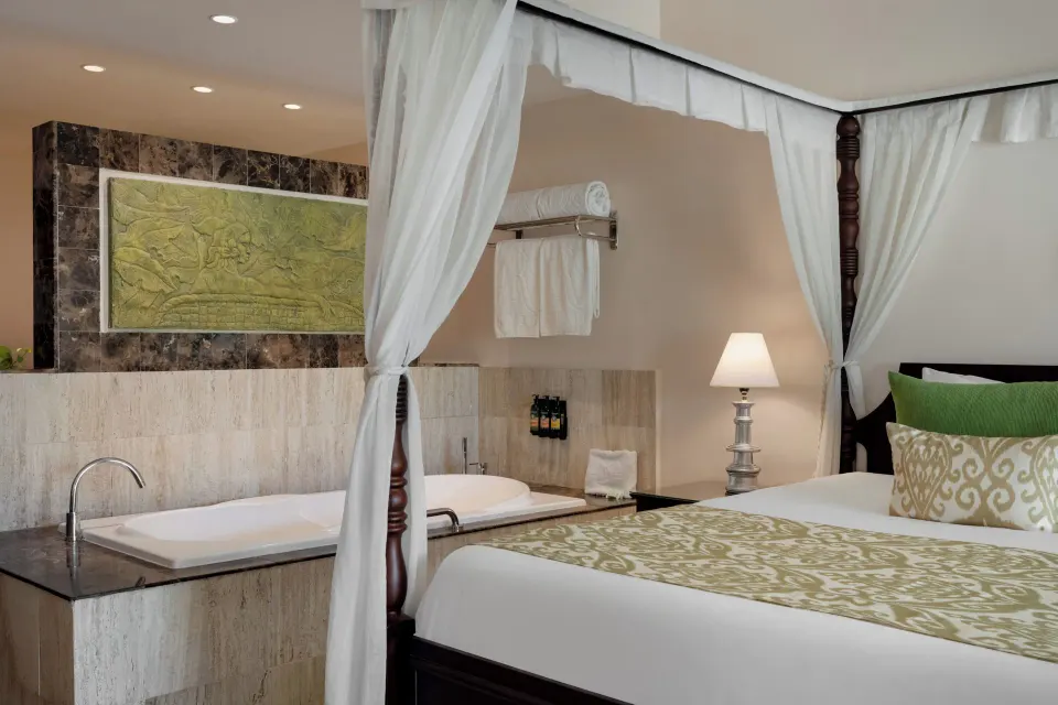 Junior Suite Swim Up bed beside a soaking tub at TRS Turquesa Hotel.