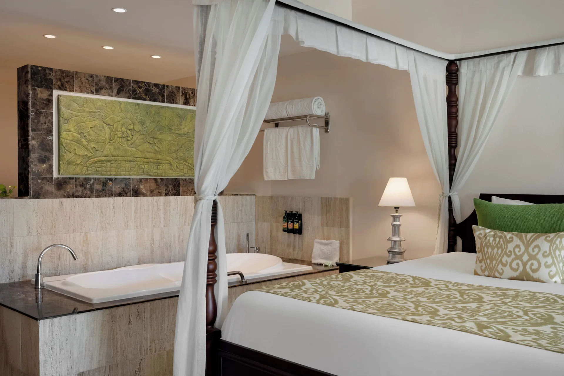 Junior Suite Swim Up bed beside a soaking tub at TRS Turquesa Hotel.