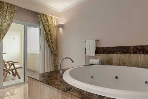 Romance Suite Poolside jetted tub beside balcony doors at TRS Turquesa Hotel.