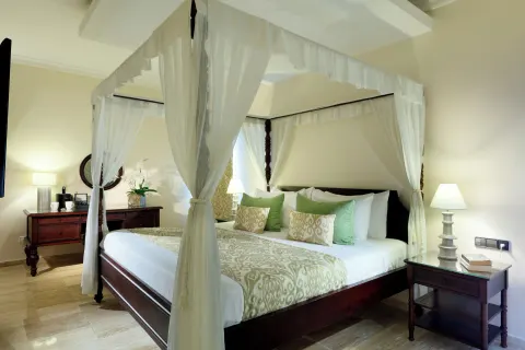 Romance Suite Poolside canopy bed with bedside lamps at TRS Turquesa Hotel.