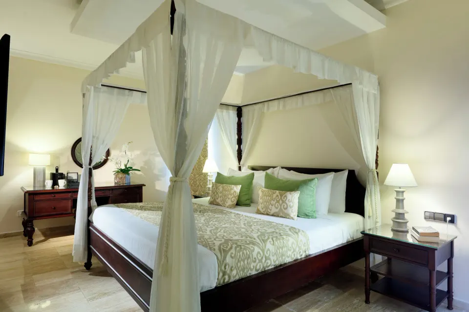 Romance Suite Poolside canopy bed with bedside lamps at TRS Turquesa Hotel.