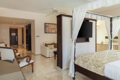 Romance Suite Swim Up bedroom view with canopy bed and sitting area at TRS Turquesa Hotel.
